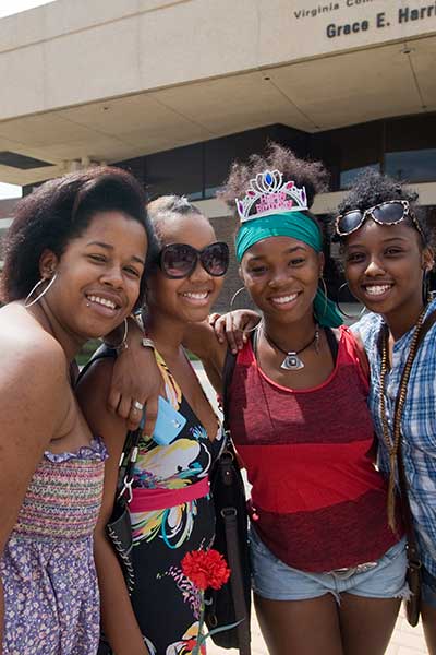 a group of students smiling outside the Grace E. Harris Hall