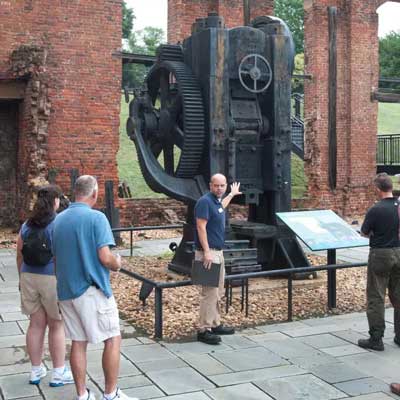a tour guide showing tourists around tredegar iron works in richmond virginia