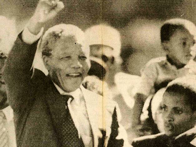 newspaper photo of nelson mandela with a raised hand